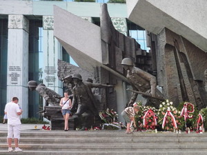Eine Frau posiert vor dem Denkmal des Warschauer Aufstandes