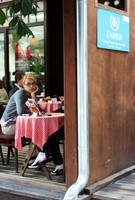 Straßencafe, daneben ein Schild mit der Aufschrift UNIFEM